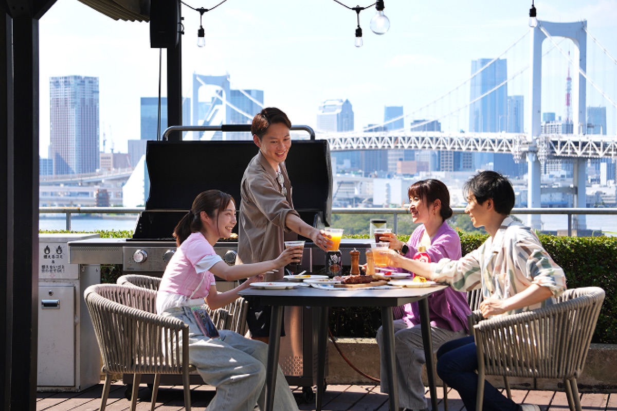 屋外テラスでBBQを楽しむ若者たちの様子